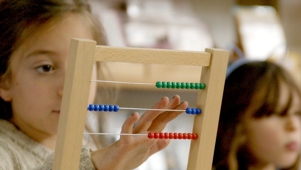 A child working with a Montessori bead frame